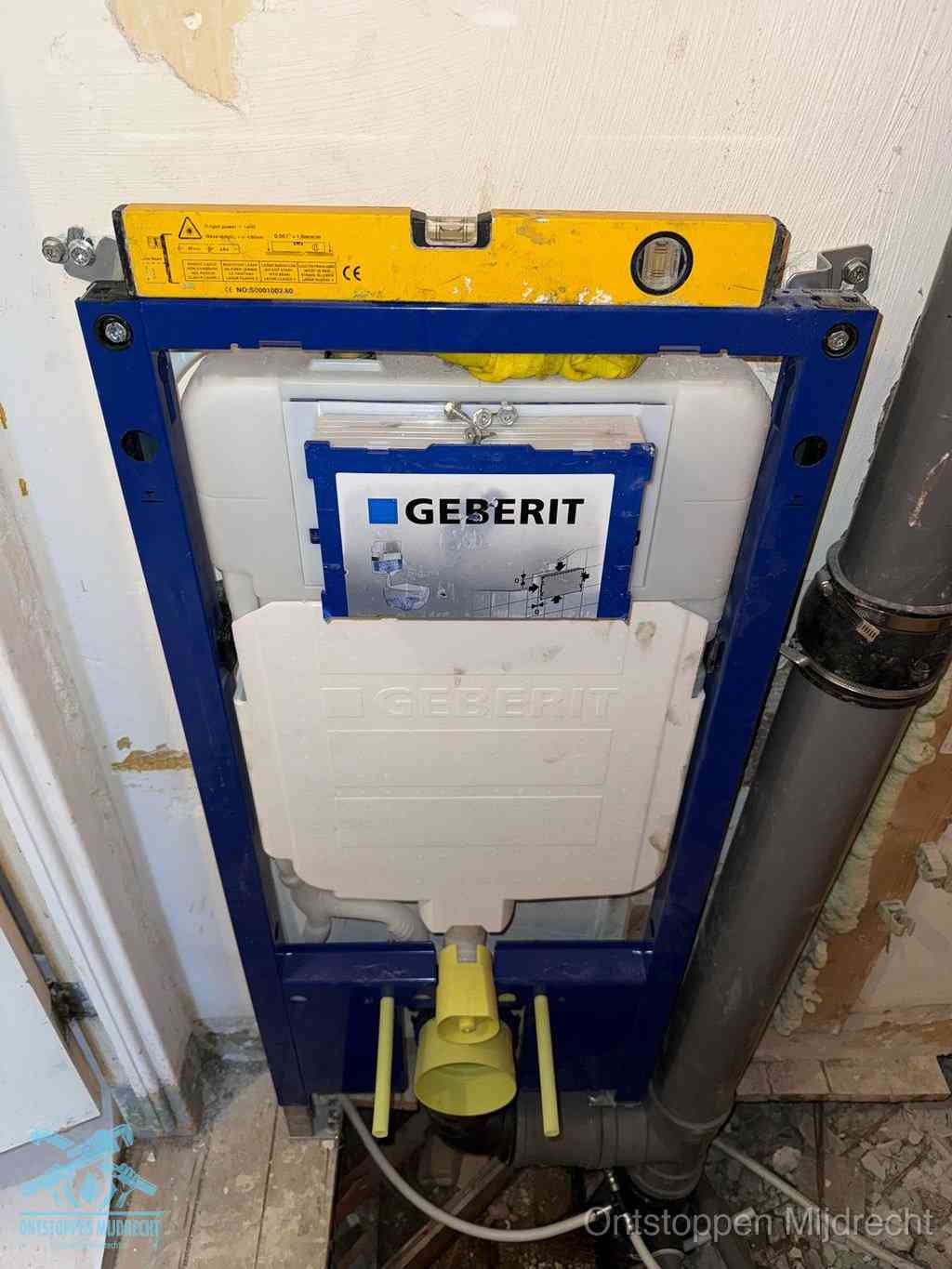 Een Geberit inbouwreservoir met frame voor een hangtoilet tegen de wand, met de afvoerbocht naar de vloer, kenmerkend voor een verstopt hangtoilet in Mijdrecht