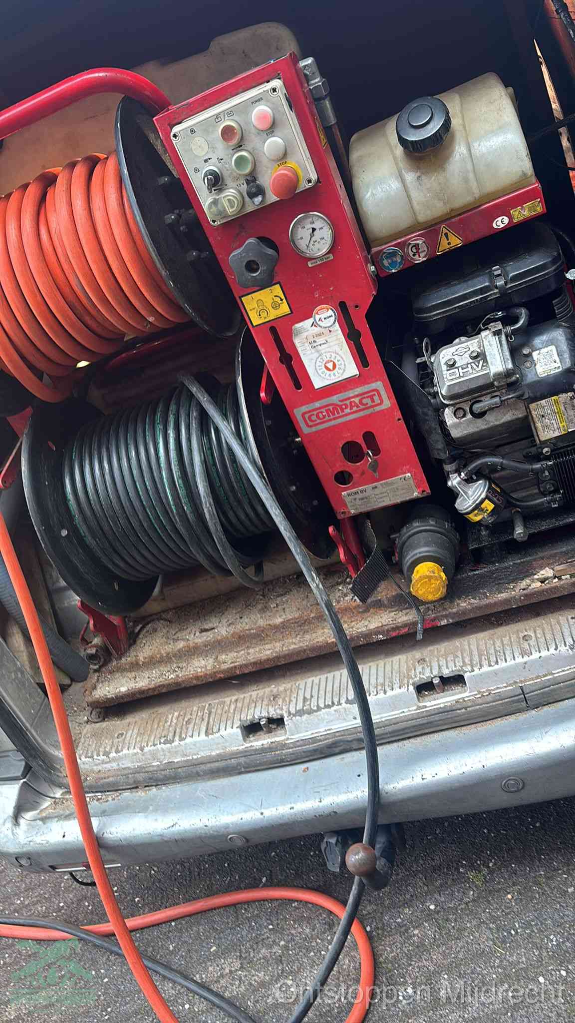 Een rood hogedruk-rioolreinigingstoestel in de laadbak van de bedrijfsbus, apparatuur voor een hardnekkige afvoerverstopping in Mijdrecht