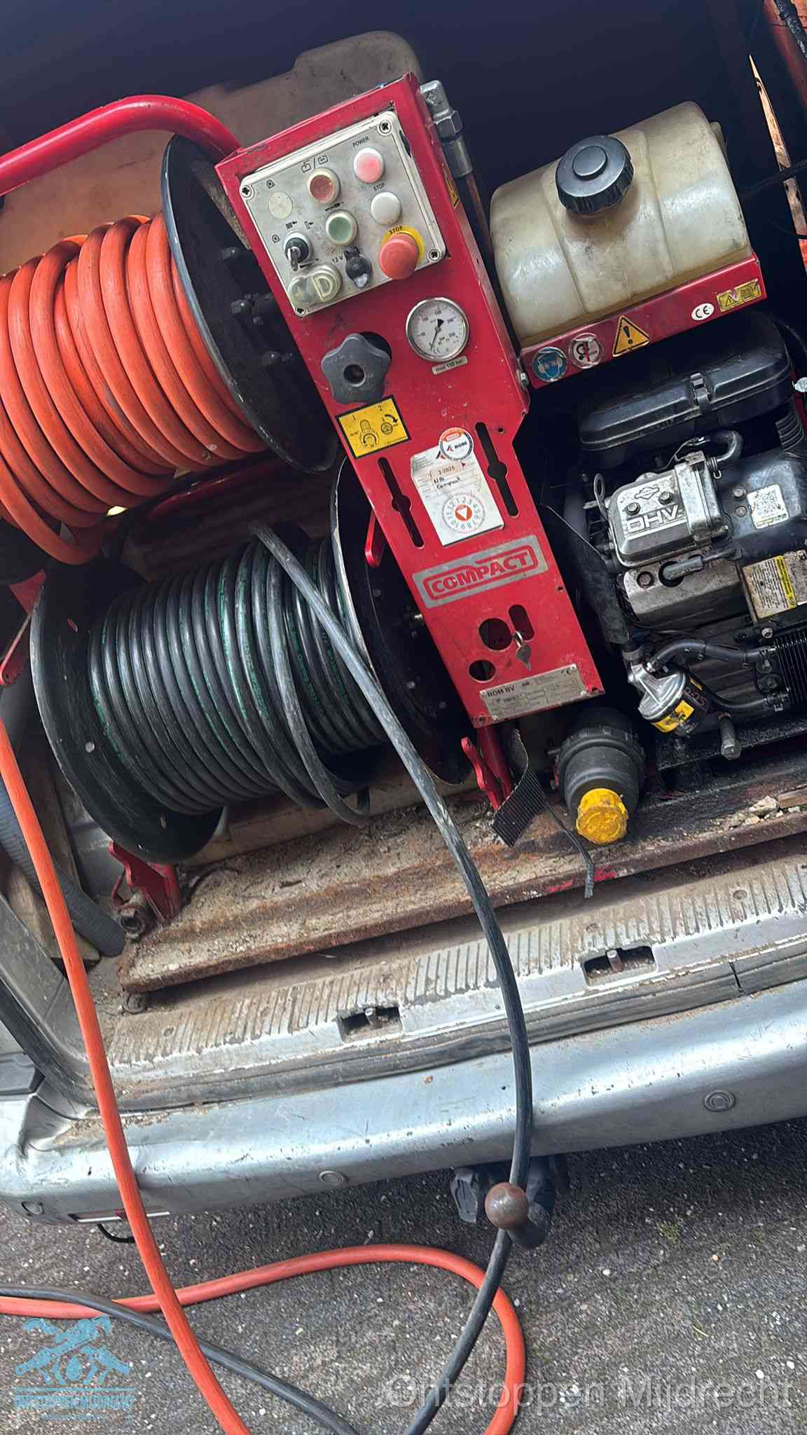 Een rood hogedruk-rioolreinigingstoestel met slangen in de laadbak van de bedrijfsbus, apparatuur voor een hardnekkige wc-verstopping in Mijdrecht