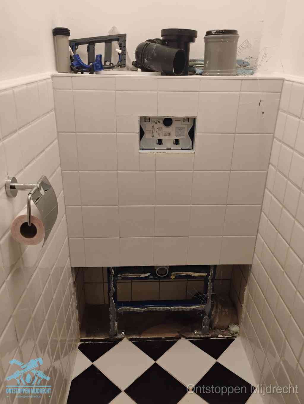 Een toiletruimte waar het hangtoilet en de inbouwreservoir-onderdelen zijn vrijgelegd voor onderhoud, periodiek nazicht voorkomt een wc-verstopping in Mijdrecht