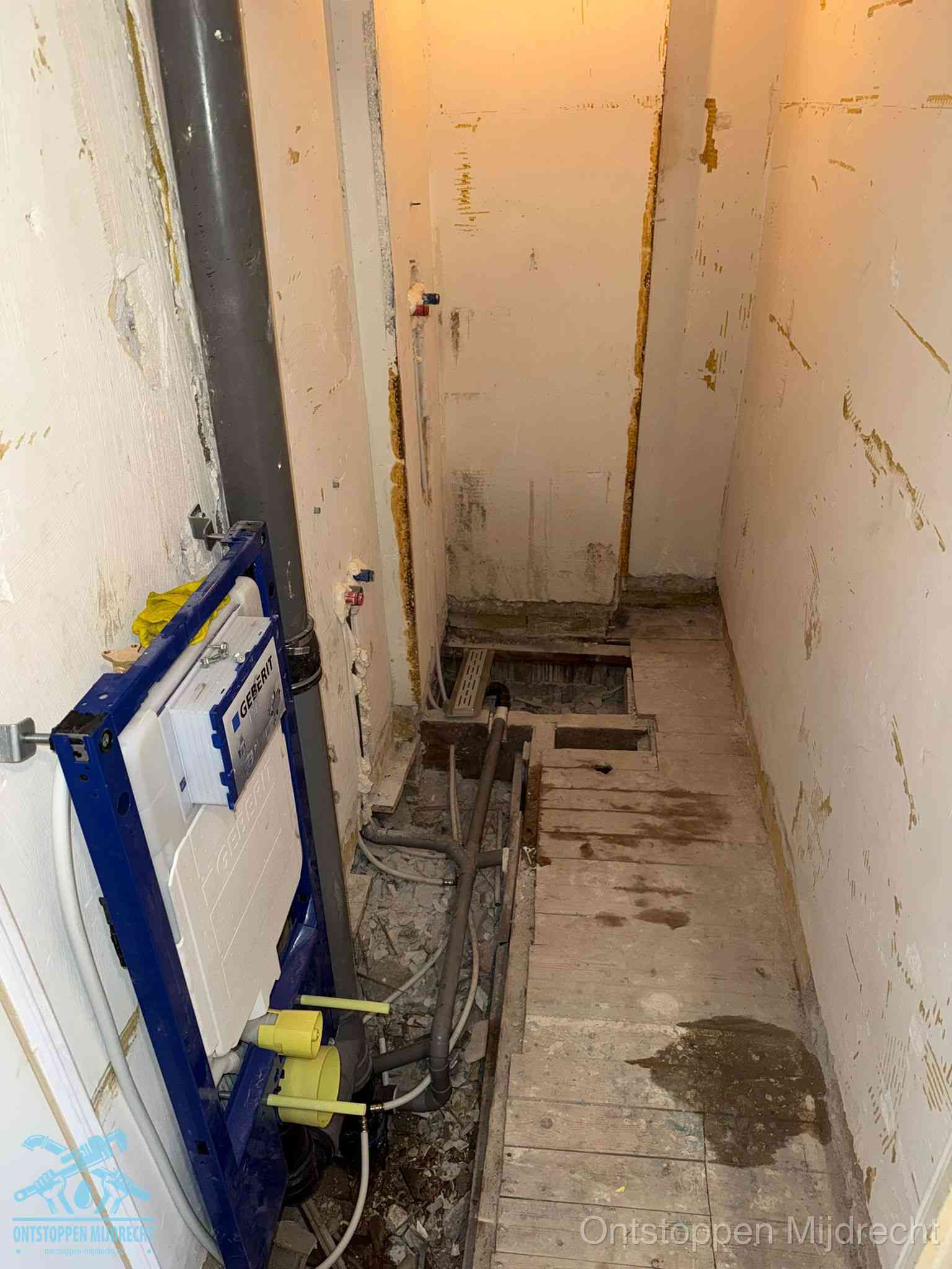 Een opgebroken toiletruimte tijdens renovatie met een Geberit inbouwreservoir en blootliggende oude afvoerleidingen, typisch voor oudere woningen in Mijdrecht